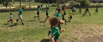 Local school children participate in a Physical Education class run by volunteers in Belize. A group of volunteers in Belize run a sports coaching class at a local school.